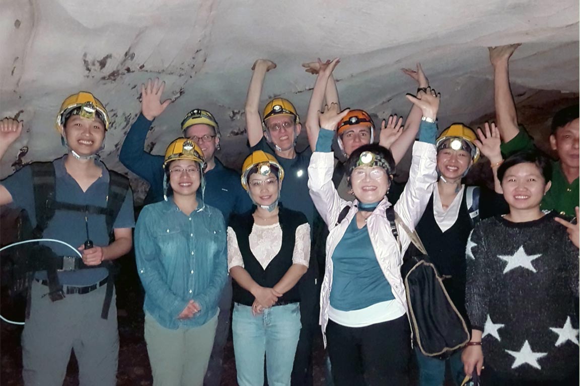Group of people smiling for the camera in a cave