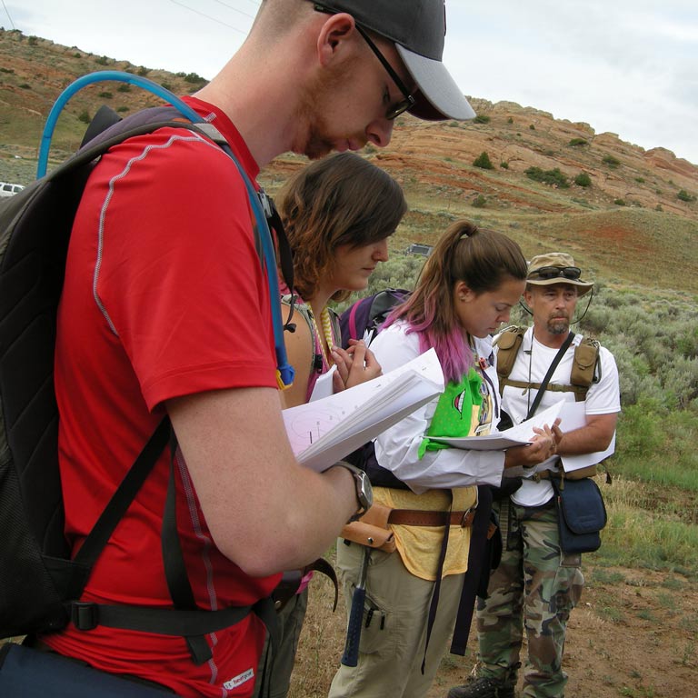 Students looking through notes out in the field